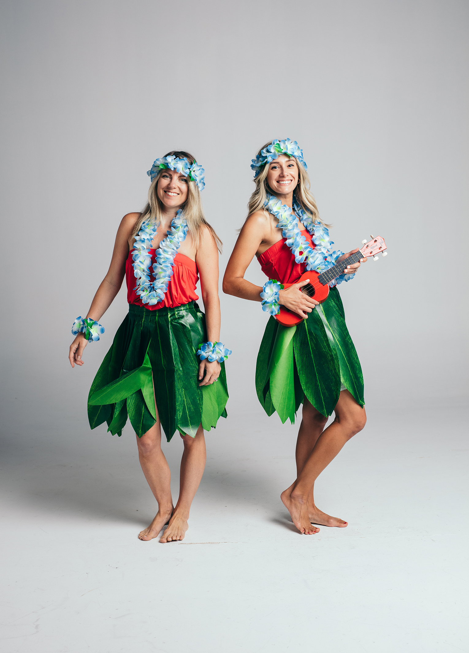 Two women in hawaiian costumes posing for a photo.