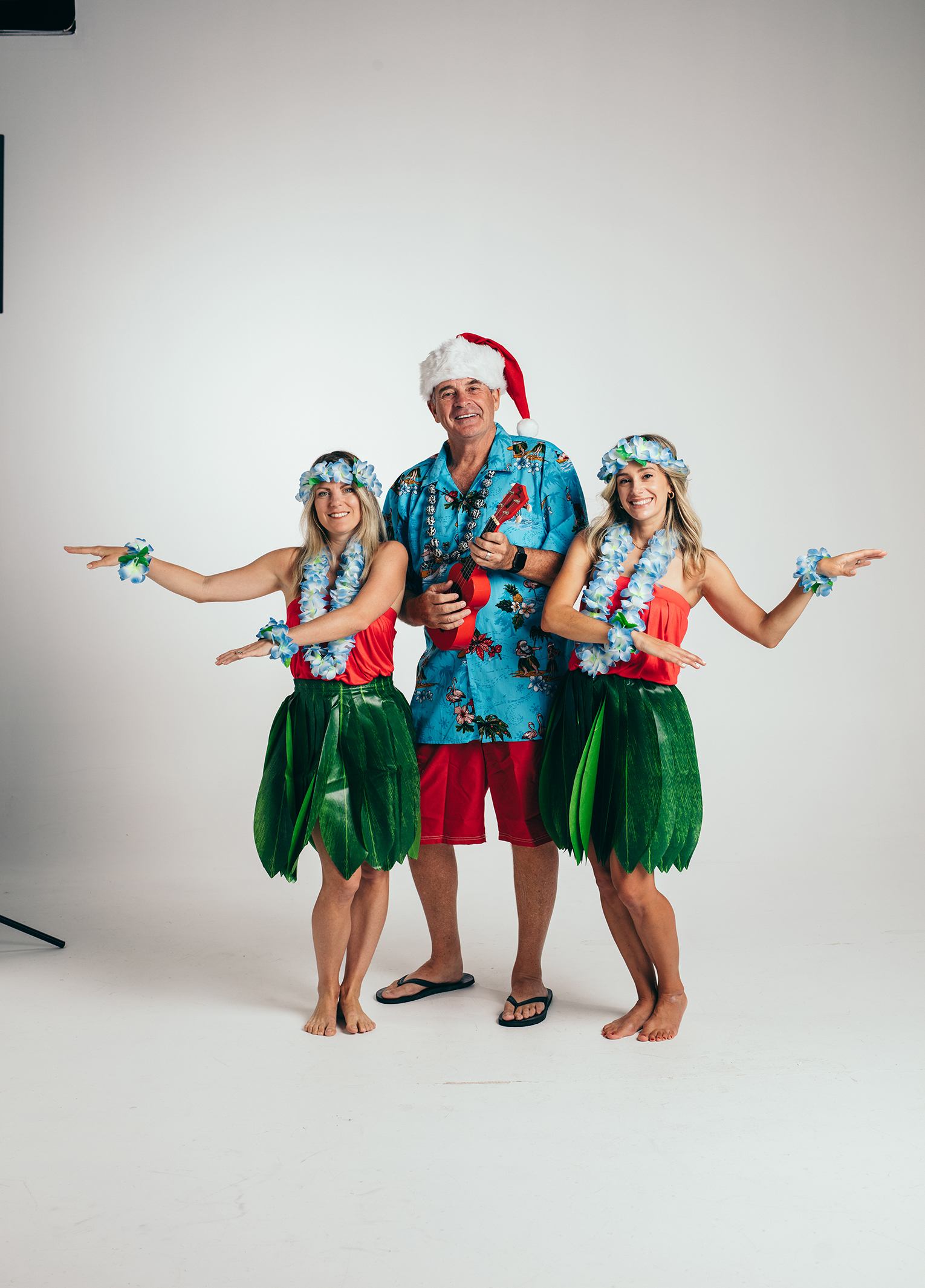 Three women in hula costumes posing for a photo.