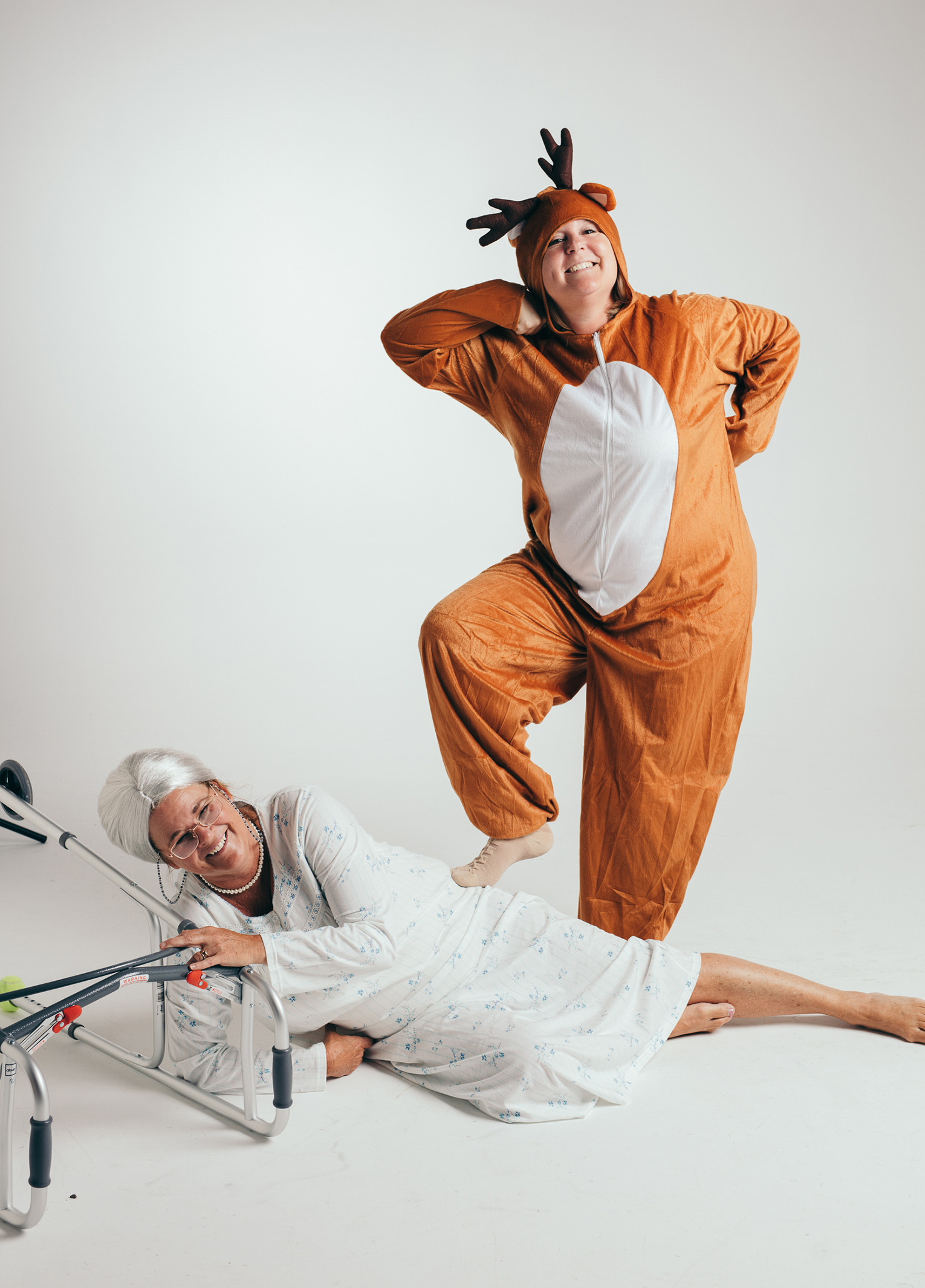 A woman in a reindeer garment and a woman in a hospital bed.