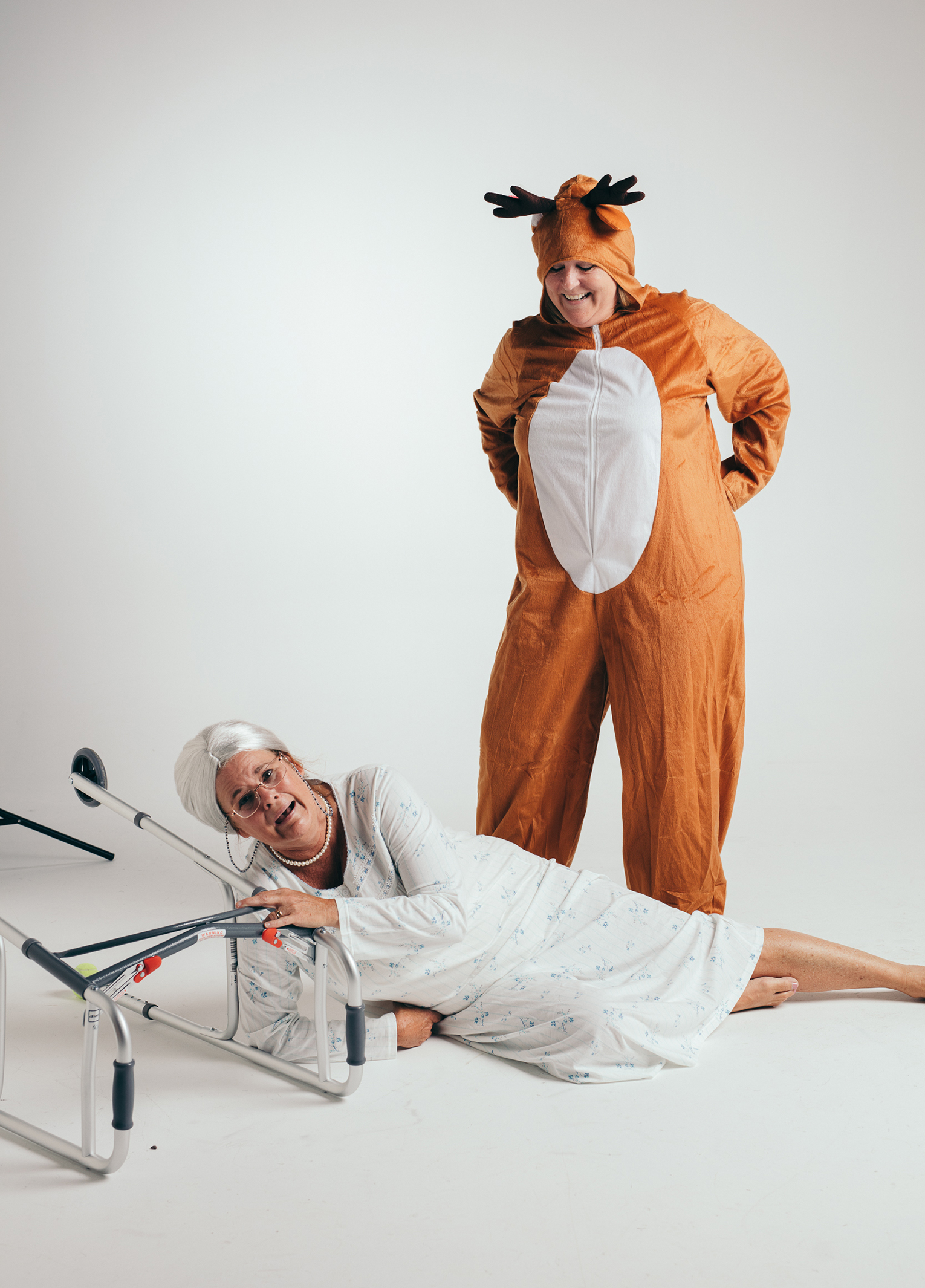 A woman in a garment with a crutch next to a person in a reindeer garment.