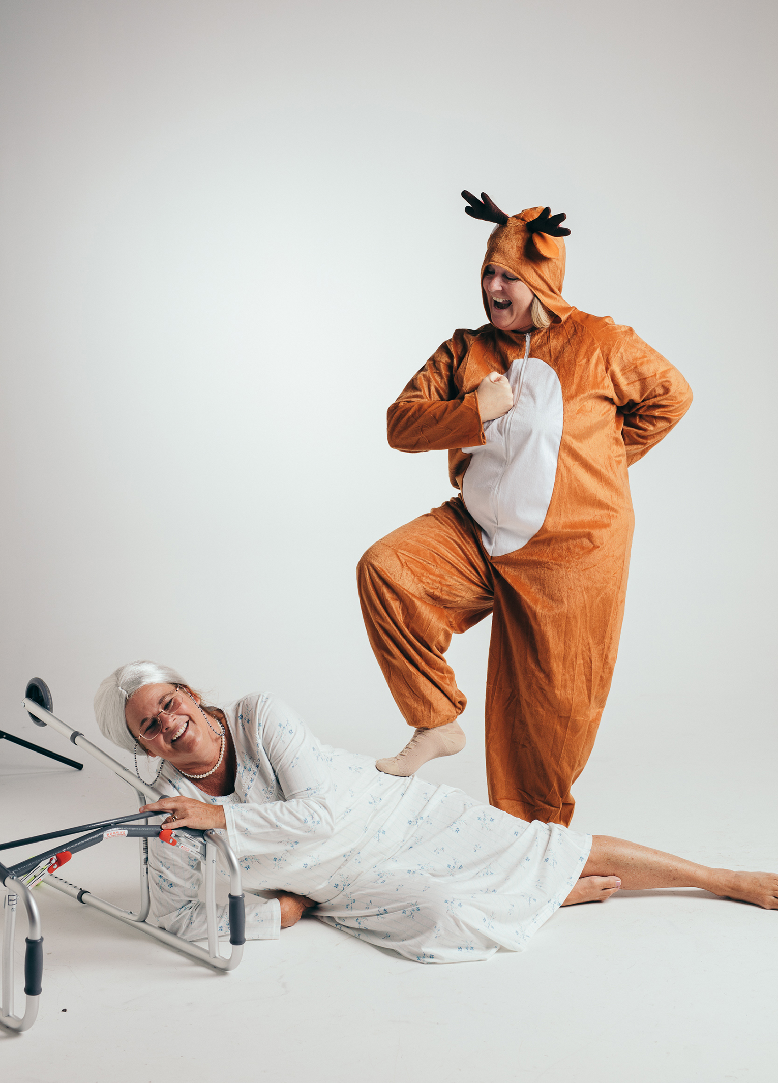 A man in a garment next to a woman lying on a bed.