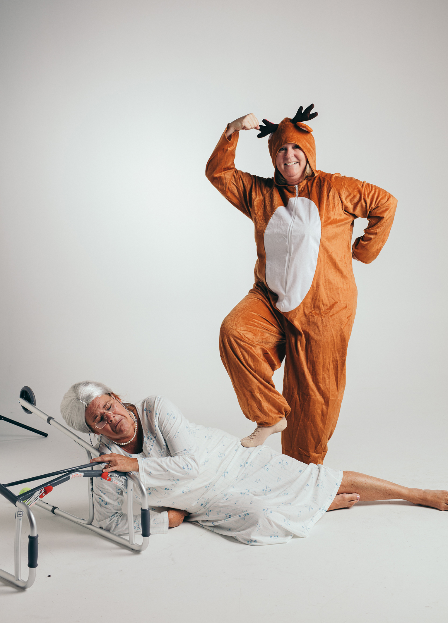 A man and woman dressed as a reindeer laying on a bed.