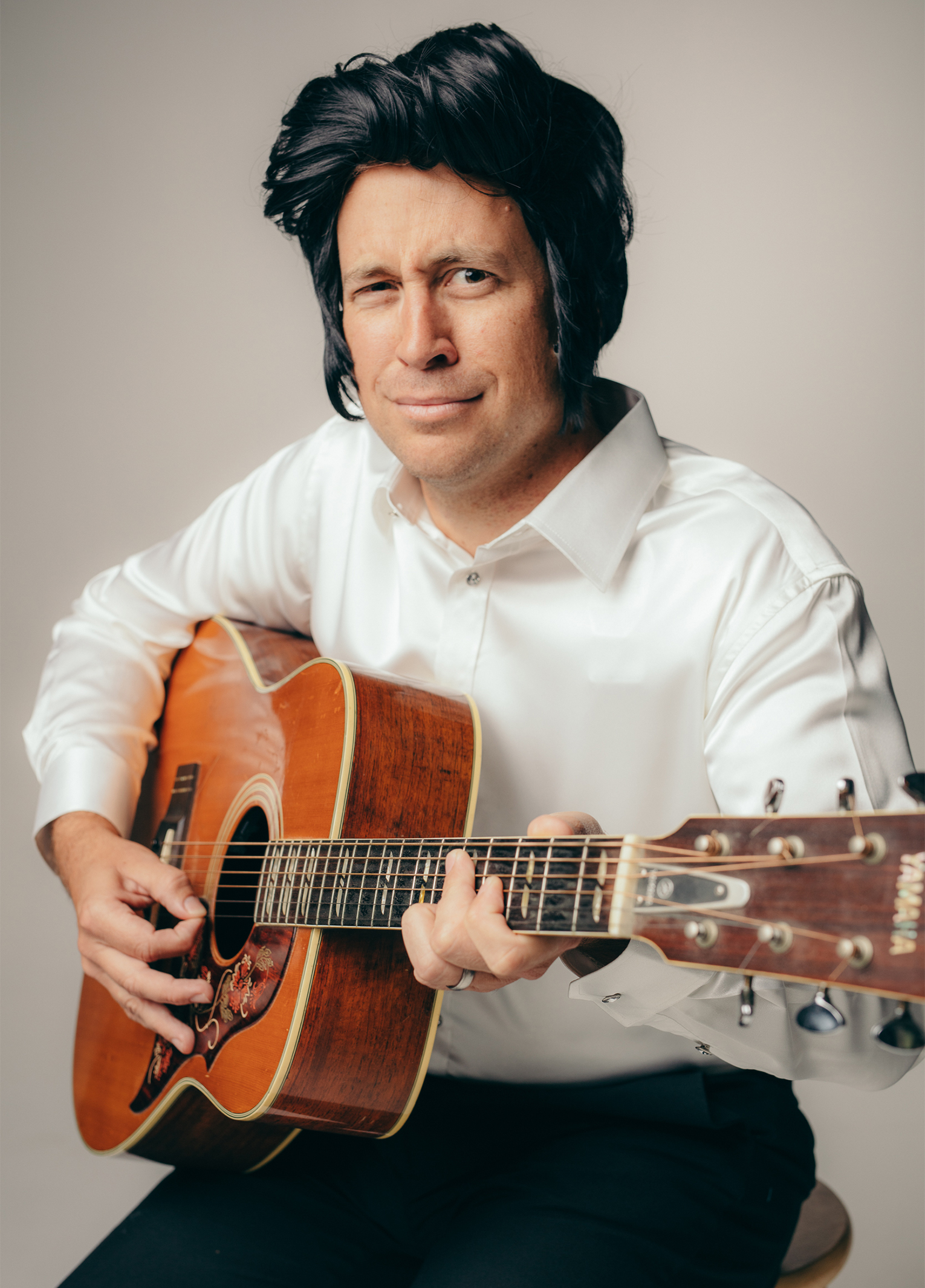 A man holding an acoustic guitar.