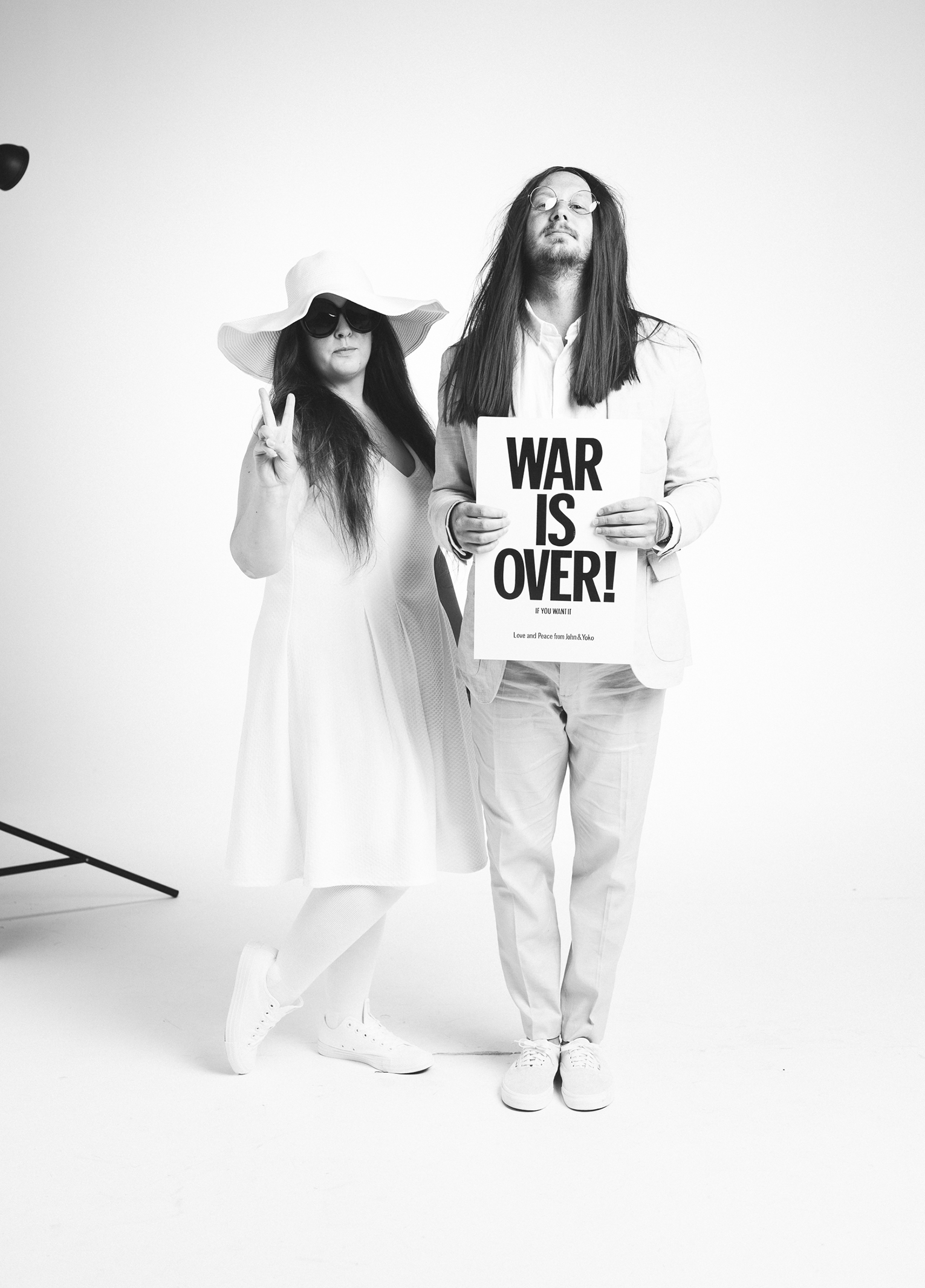 A man and woman holding a sign that says war is over.