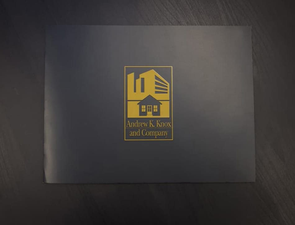 A black book with a gold logo on it.