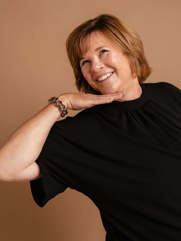 A woman in a black top posing for a photo.
